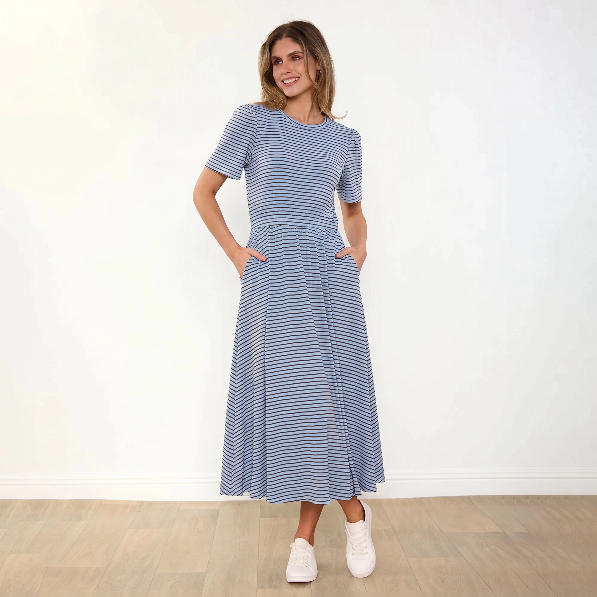 Eilish Dress (Blue/Brown) - Front, warm smile, hands in pockets