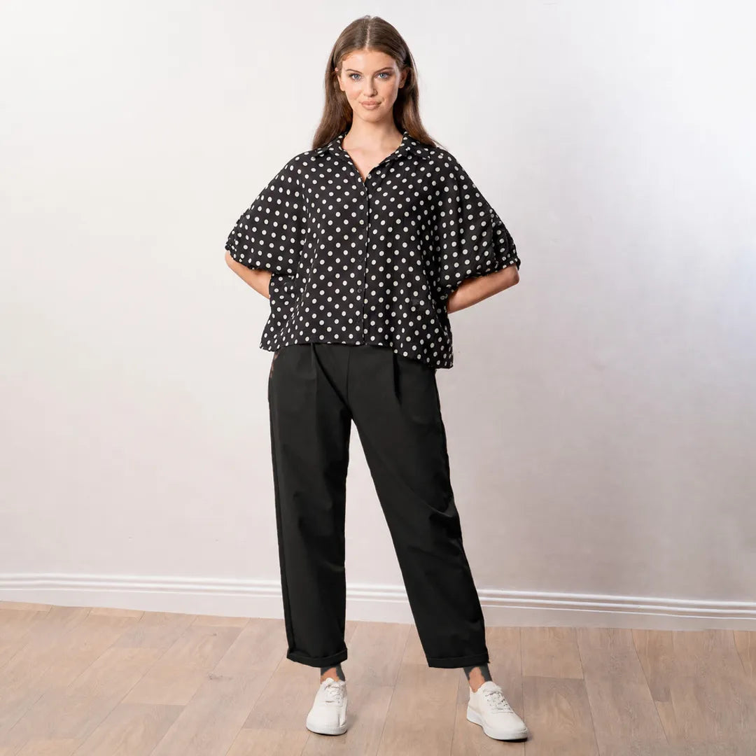 Athena Top in black polka dot, relaxed front view with hands behind back