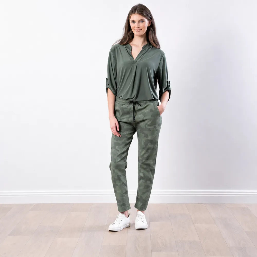 Woman wearing the Stella Jogger in army camo print with an olive green blouse and white trainers, front view