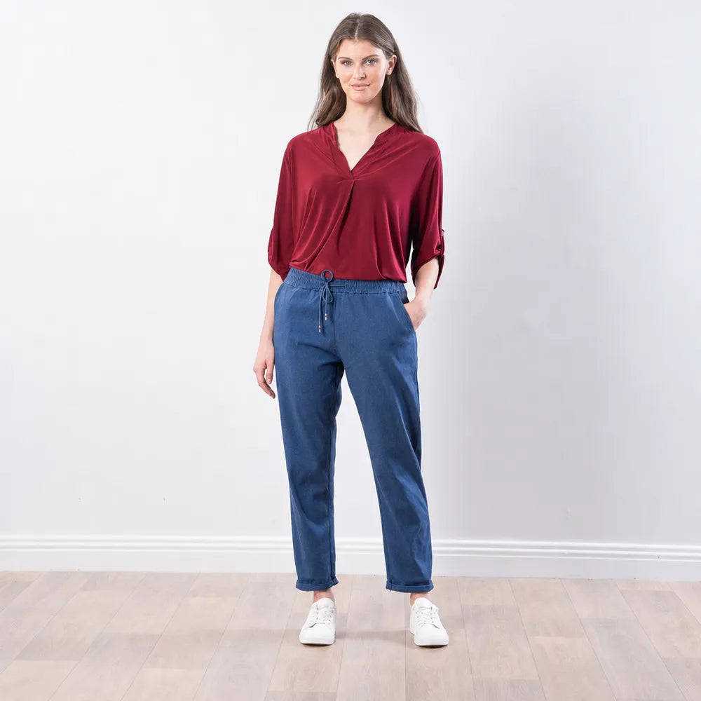 Woman wearing The Casual Company Stella Jogger in denim blue with a burgundy blouse and white trainers, front view