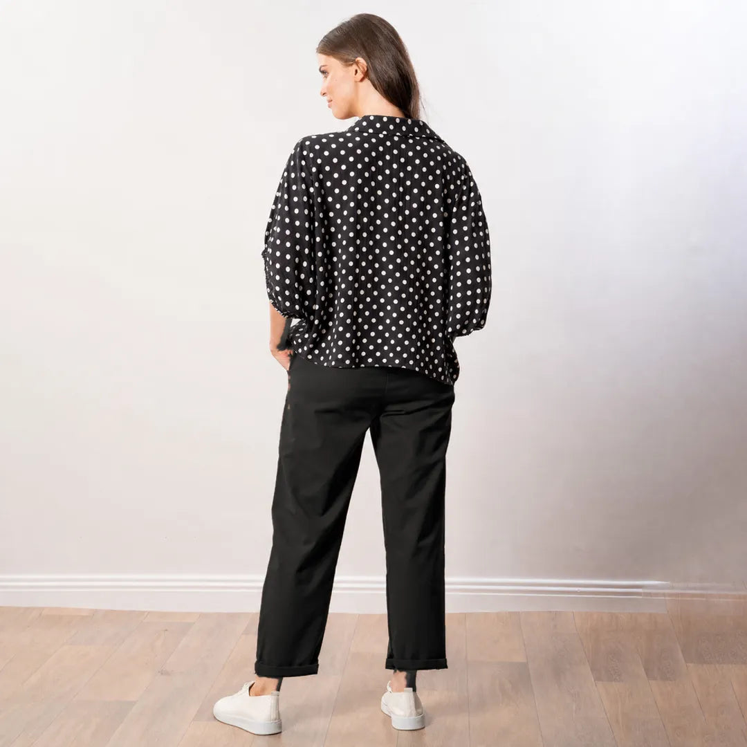 Athena Top in black polka dot, back view showing curved hem and gathered sleeve edges