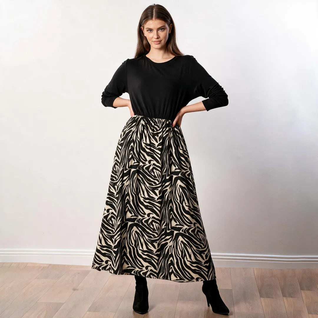 Audrey Dress in black and cream zebra print — front view, hands on hips, showing gathered maxi skirt