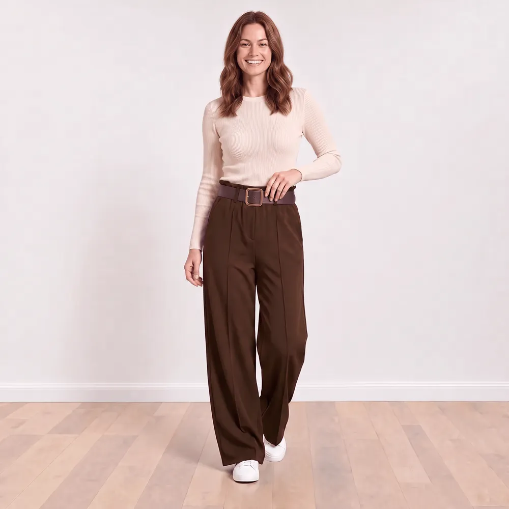 Ellana Trousers in brown — model with hand resting at the paperbag waistband, front view